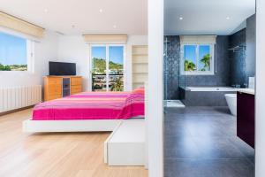 a bedroom with a bed and a tub and a television at Ático Las Palmeras in Cala Millor +17 photos