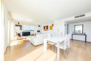 a white living room with a white table and chairs at Ático Las Palmeras in Cala Millor