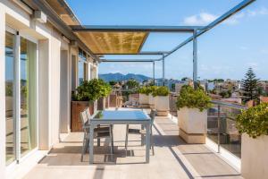 a patio with a table and chairs on a balcony at Ático Las Palmeras in Cala Millor