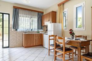 a kitchen with a table and a white refrigerator at Daratos apartment 3 in Kefallonia +12 photos