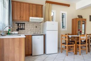 a kitchen with a white refrigerator and a table at Daratos apartment 3 in Kefallonia