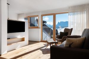 a living room with a television and a balcony at Kardinerhof in Collalbo