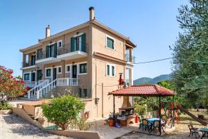 a large house with a playground in front of it at Daratos apartment 3 in Kefallonia