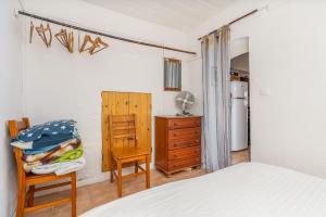 a bedroom with a bed and a chair and a dresser at Casa da Praia 2 in Budens