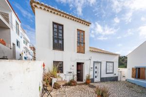 a white house with a courtyard at Casa da Praia 2 in Budens
