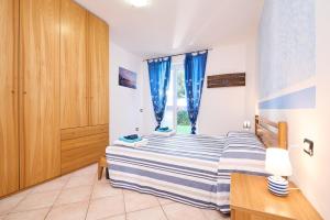a bedroom with a bed with blue curtains at Blu - Euroappartamenti in San Vincenzo +18 photos
