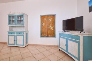a room with a tv on a dresser and a door at Blu - Euroappartamenti in San Vincenzo