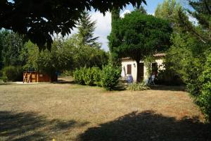 a small house in a yard with trees at Haus Zypresse in Saint-Saturnin-lès-Apt
