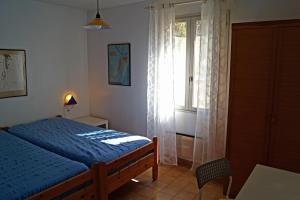 a bedroom with a blue bed and a window at Haus Zypresse in Saint-Saturnin-lès-Apt