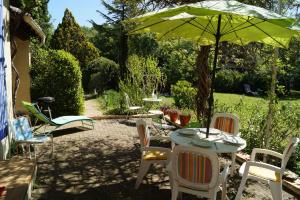 a patio with a table and chairs and an umbrella at Haus Zypresse in Saint-Saturnin-lès-Apt