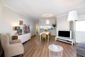 a living room with a couch and a tv and a table at Palmeira Galé in Galé