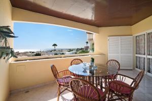 a balcony with a table and chairs and a window at Palmeira Galé in Galé