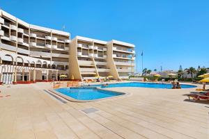 a large building with a swimming pool in front of it at Palmeira Galé in Galé