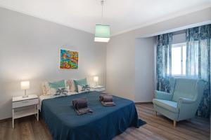 a bedroom with a blue bed and a blue chair at Palmeira Galé in Galé +15 photos