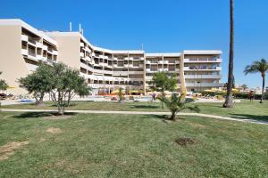 a large white building with trees in front of it at Palmeira Galé in Galé