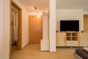 a living room with a television on a cabinet at Casa Rindler in Sigmarszell