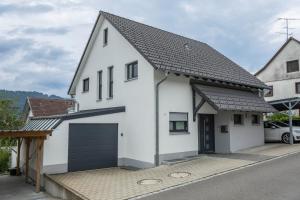 a white house with a black garage at Casa Rindler in Sigmarszell