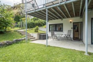 a patio with a table and chairs under a pergola at Casa Rindler in Sigmarszell +9 photos