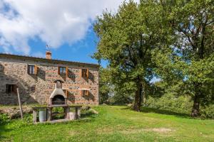 an old stone building with an oven in the yard at Casetta di Ugolino in Radicofani