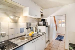 a kitchen with a sink and a white refrigerator at Haus am Rand des Harz in Bad Lauterberg