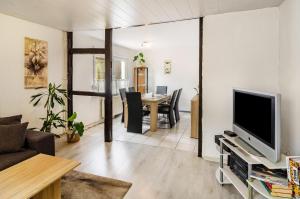 a living room with a television and a table with chairs at Haus am Rand des Harz in Bad Lauterberg