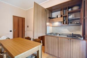 a kitchen with wooden cabinets and a wooden table at Appartamento Bilocale Moneglia 21 in Moneglia