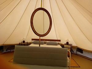 a bed with a mirror in a tent at Glamping C Selva Tenda Ciliegio in Piano Porlezza
