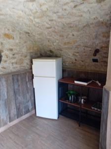 a white refrigerator in a room with a wall at Glamping C Selva Tenda Ciliegio in Piano Porlezza