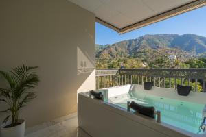 a balcony with a jacuzzi tub with a mountain view at Perfectstayz Premium Dehradun at Rajpur road in Dehradun