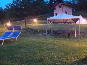 a tent and two chairs in a field at night at Glamping C Selva Tenda Ciliegio in Piano Porlezza +4 photos