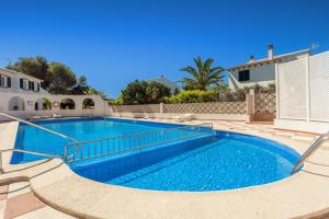 a swimming pool with blue water in a yard at Villa Seve in Cala en Bosc