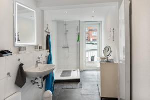 a white bathroom with a sink and a shower at Haus am Nicolaiplatz in Salzwedel +18 photos