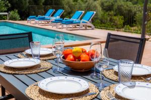 a table with a bowl of fruit and glasses at Finca Ca'n Terrasa in Capdepera