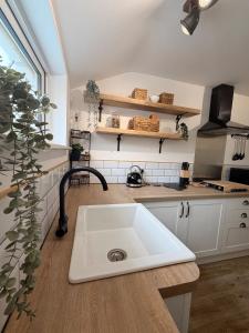 a kitchen with a white sink and a counter at Joshua House in Newquay