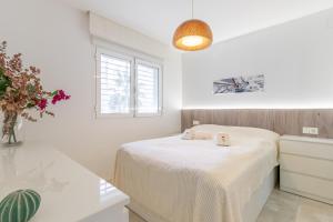 a white bedroom with a bed and a window at Albir Playa in Alfaz del Pi +17 photos