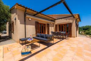 a patio with a couch and a table at Finca Ca'n Terrasa in Capdepera