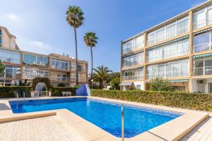 a swimming pool in front of a building at Albir Playa in Alfaz del Pi
