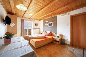 a room with a bed and a television in it at Lingerhof Alpenrose in Meltina
