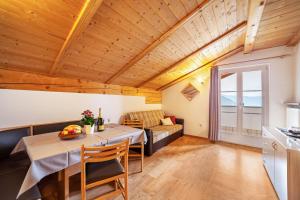 a dining room with a table and a couch at Lingerhof Alpenrose in Meltina