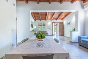 a dining room with a table and a blue couch at Villa Lorenzo in Avola