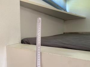 a ruler on a shelf in a room with a bed at Tiny Haus an der Schlei in Kosel