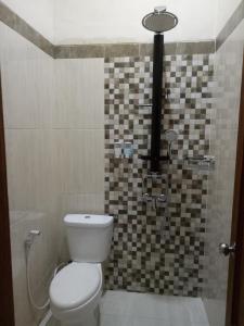 y baño con aseo y ducha. en Nariska Suite Homestay Purwokerto, en Purwokerto