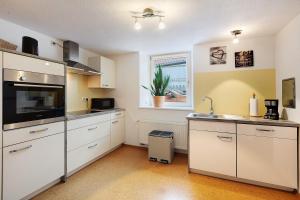 a kitchen with white cabinets and a sink and a window at Ferienwohnung Schmidt in Wehr