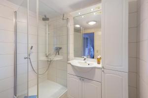 a white bathroom with a shower and a sink at Ferienwohnung Schmidt in Wehr +12 photos