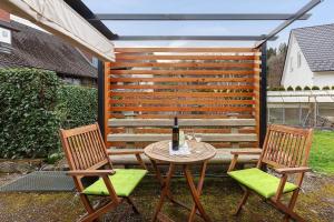 a patio with two chairs and a table with a bottle of wine at Ferienwohnung Schmidt in Wehr