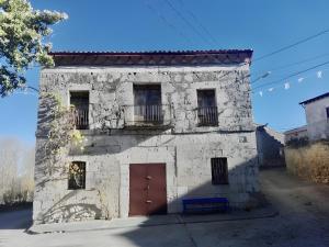 an old stone building with a red door at Reoyo 2 in Mambrilla de Castrejón