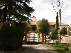 a building with a gate with a clock tower at Reoyo 2 in Mambrilla de Castrejón