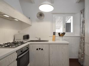 a white kitchen with a stove and a sink at Casa 23 in Castiadas