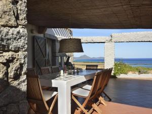 a table and chairs on a patio with a view of the ocean at Casa 23 in Castiadas