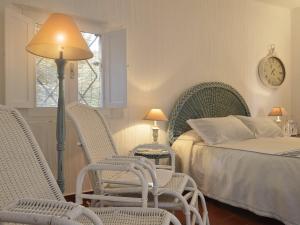a bedroom with chairs and a bed with a clock on the wall at Casa 23 in Castiadas